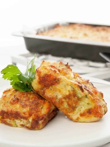 Close up view of individual zucchini slice on white plate and background