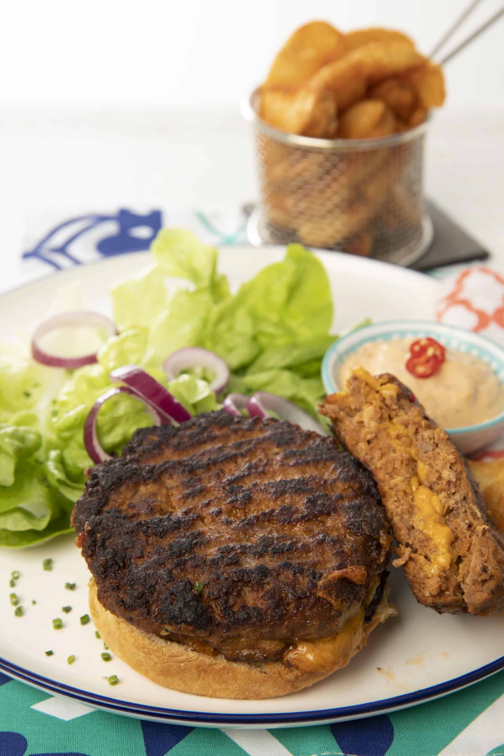 Double stuffed cheese burger on a plate with fries.