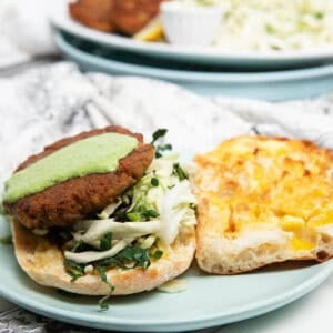 Salmon burger on a plate with slaw and dressing