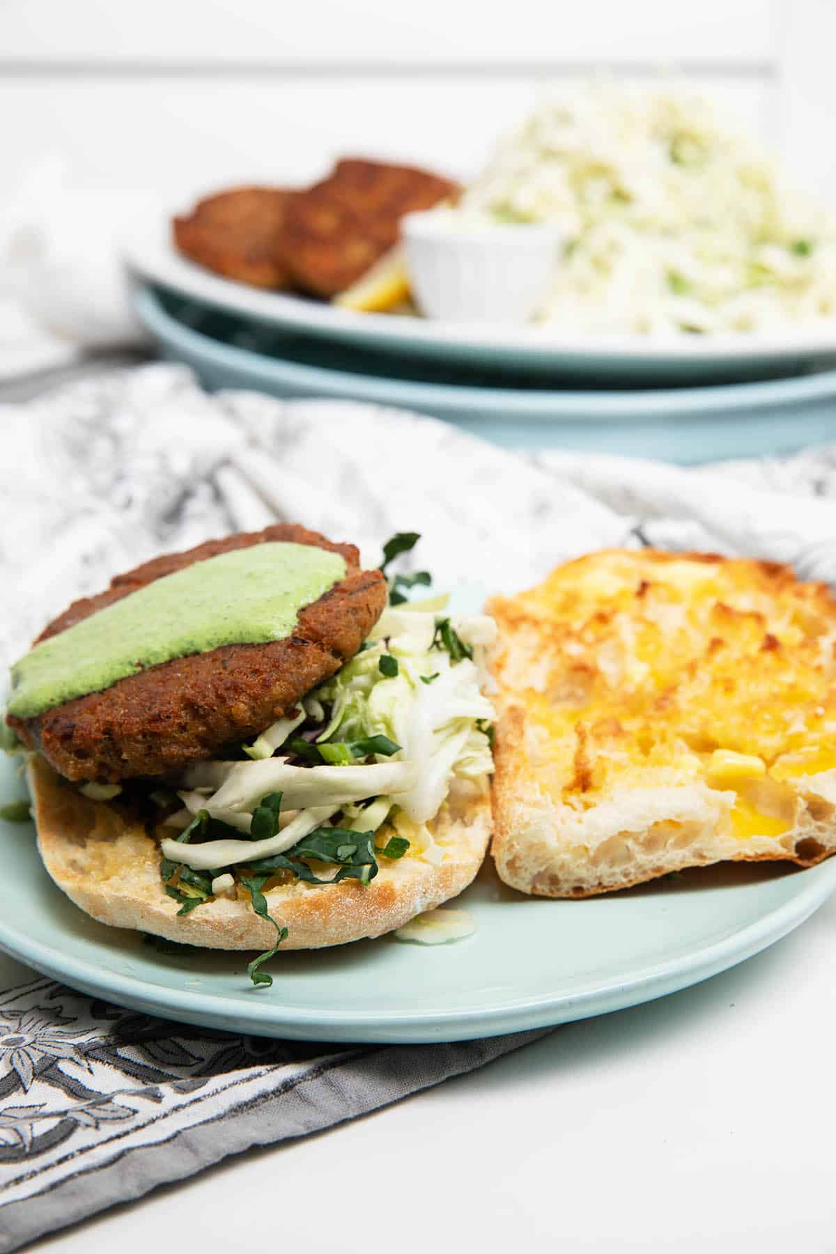 Salmon burger on a plate with slaw and dressing