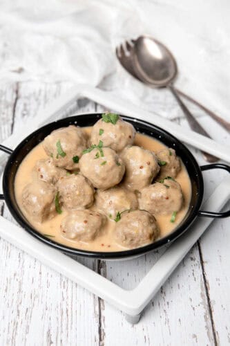 Thermomix creamy Swedish meatballs in a black dish white background