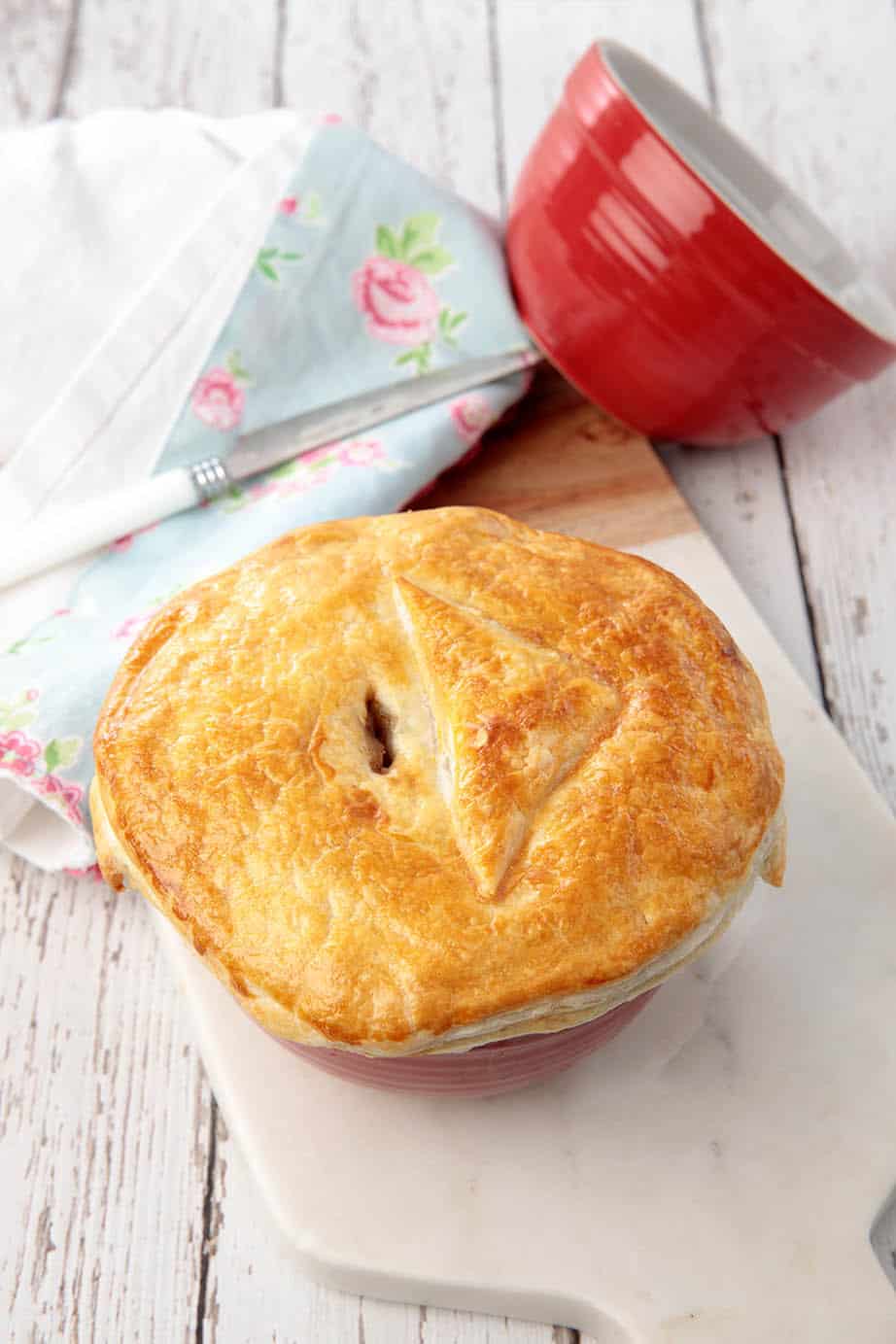 Homemade Guinness pie in a red pot on a wooden background