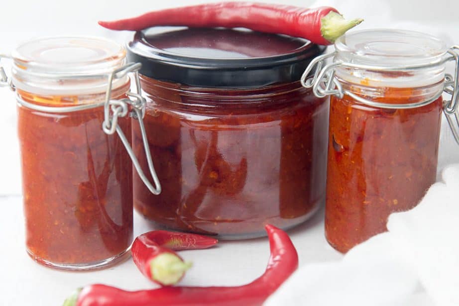 Hot Thai Chilli Sauce in glass jars on white background
