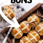 A tray of hot cross buns with an arrow pointing to them