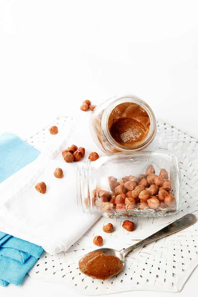 Image of hazelnuts made into Nutella on a white backgrouns