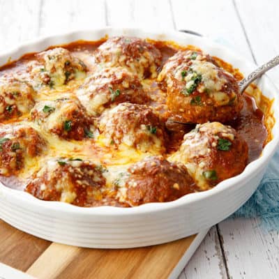 Landscape image of meatballs is tomato sauce on white background