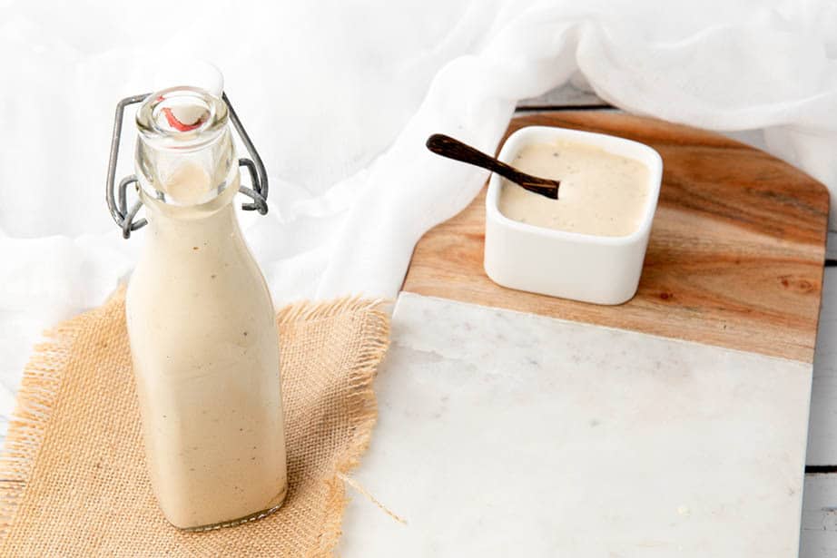 A bottle of homemade Caesar Salad Dressing on a white background