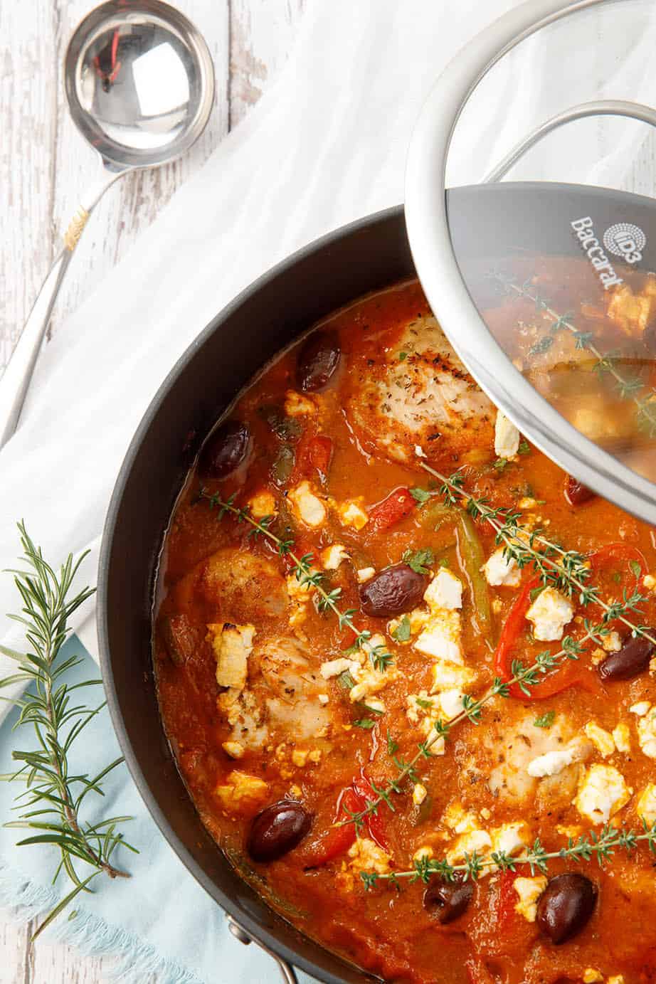 Profil pic taken overhead with Chicken cacciatore in a casserole dish on white wood background.