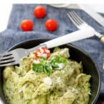 A bowl of chicken pesto on a blue teatowel