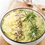 Overhead shot mashed cauliflower on wooden board and white background