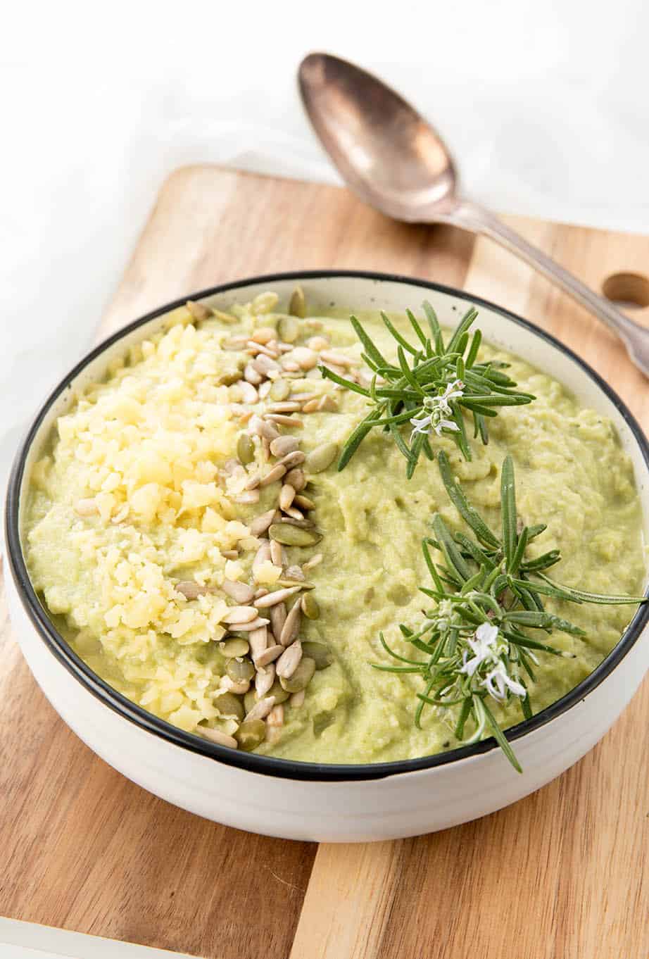 Overhead shot mashed cauliflower on wooden board and white background