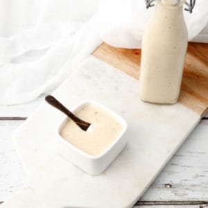 Portrait shot Homemade Caesar Salad Dressing on a white chopping board and background