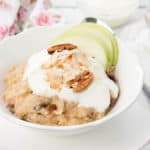 A bowl of Apple Pie Oatmeal topped with yoghurt, nuts, coconut and apple