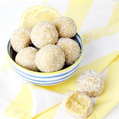 lemon bliss balls on a white background and yellow striped tea towel