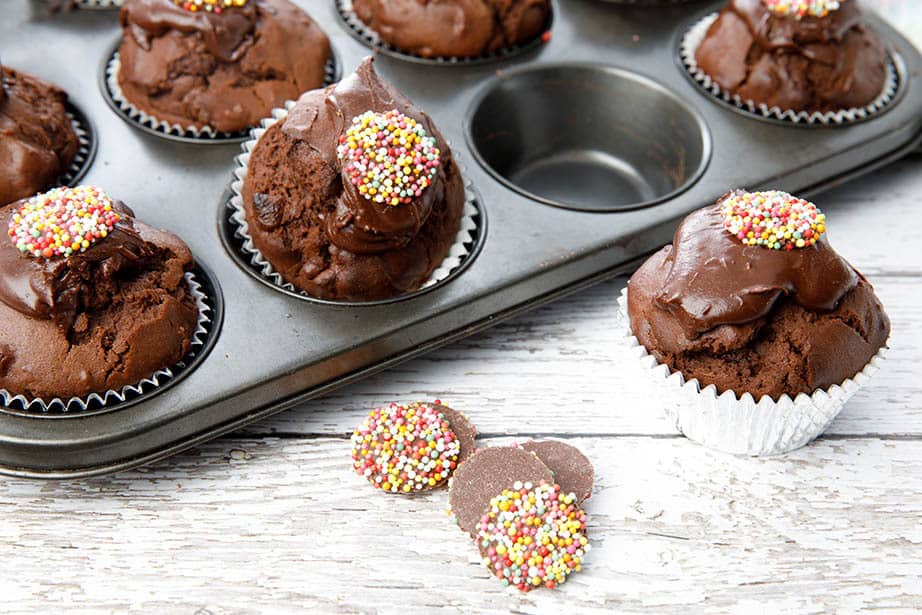 Tray of double chocolate muffins on white wood background