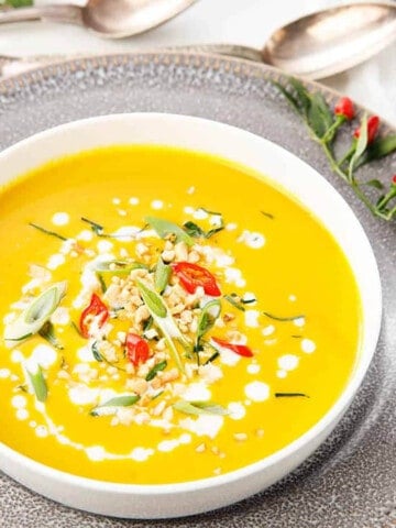 Thai Pumpkin Soup with toppings on a grey plate. Thermomix recipe