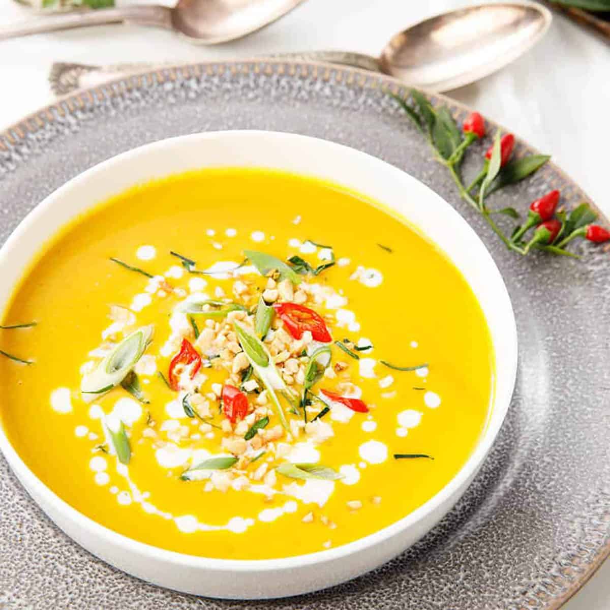 Thai Pumpkin Soup with toppings on a grey plate. Thermomix recipe