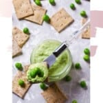 Overhead close up of smashed Bean and Pea Dip and crackers on a grey background