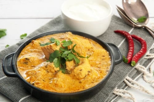 Thermomix Indian Chicken Curry on white background with yoghurt