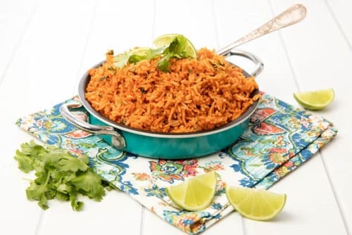 Mexican Red Rice in a blue dish on white background