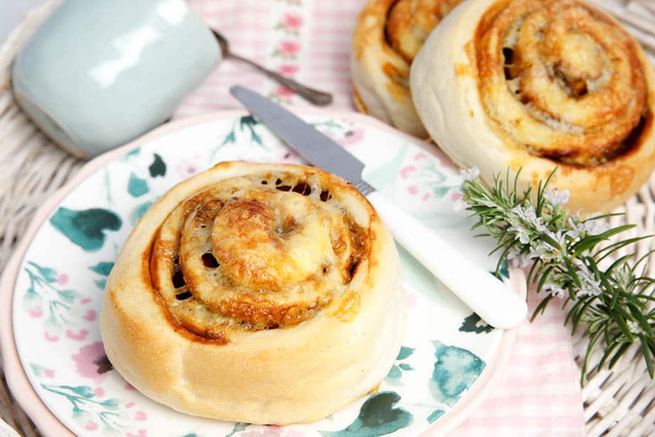 Overhead shot Cheesymite scrolls on a floral plate white knife