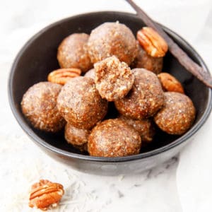 Salted Pecan Bliss Balls in Black bowl with vanilla