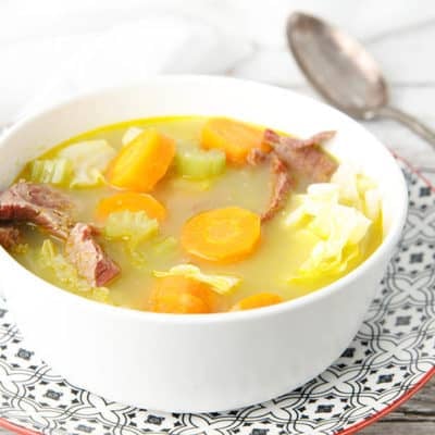 Close up white bowl with corned beef and cabbage soup