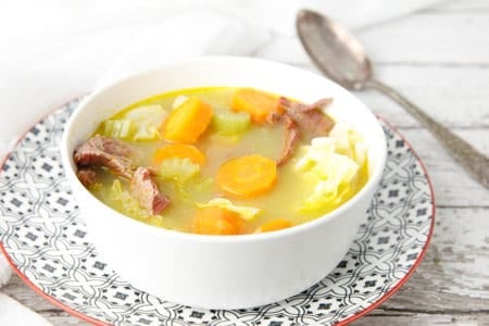 Close up white bowl with corned beef and cabbage soup