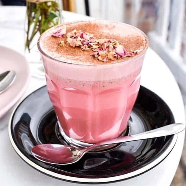 Pink Latte in a clear glass on a cafe table