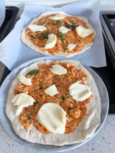 Buffalo Chicken Pizza with toppings ready for baking