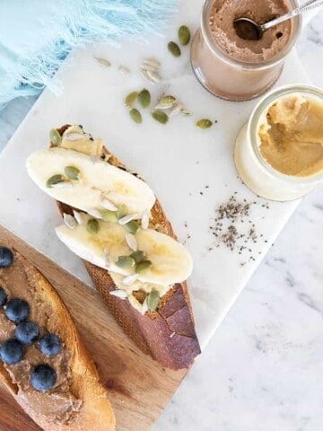 Over head shot of toast with nut butters and fruit on a chopping board