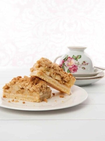 Apple Tart with Streusel topping on white background with floral tea cup