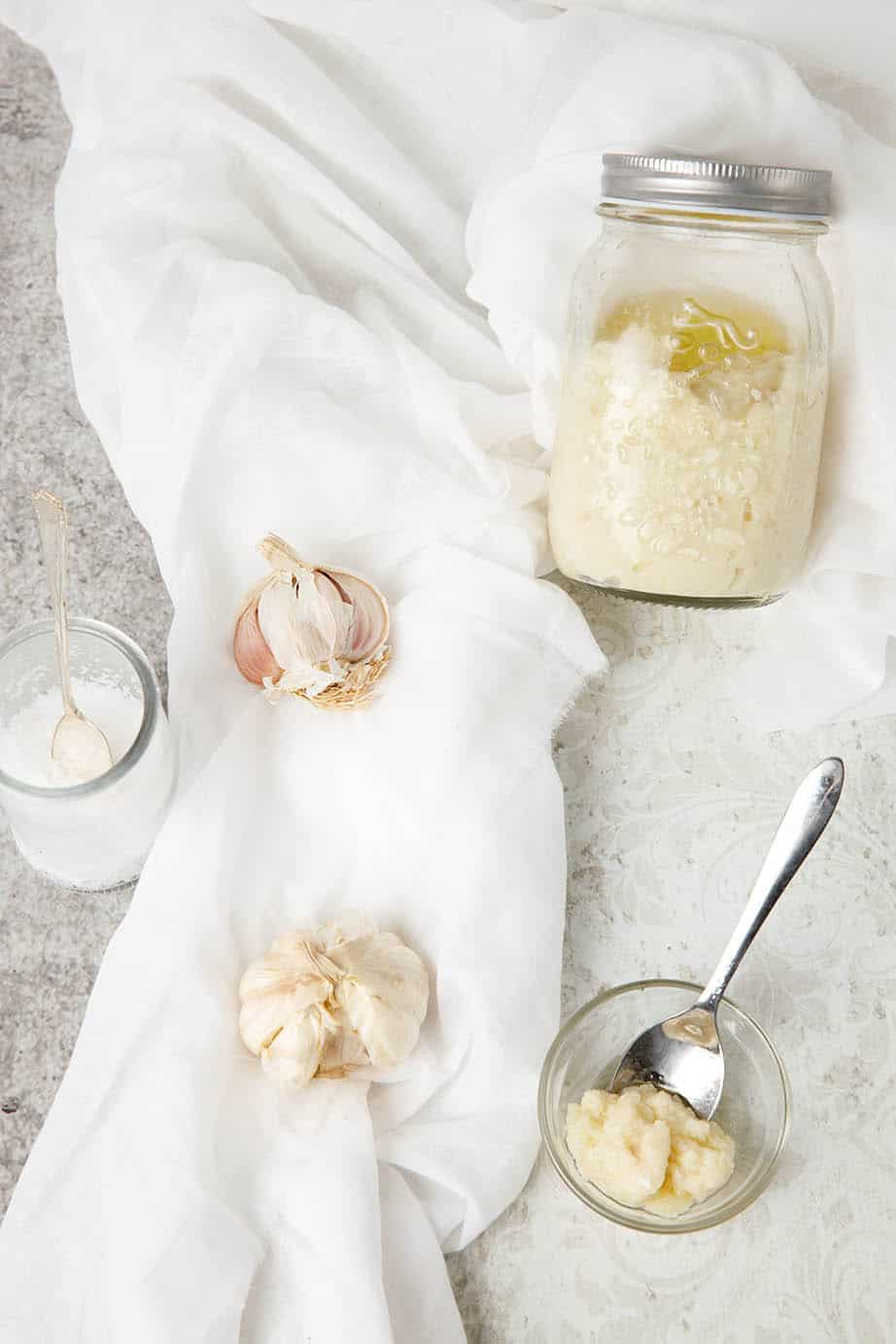 Overhead shot of homemade garlic paste on a white background showing ingredients