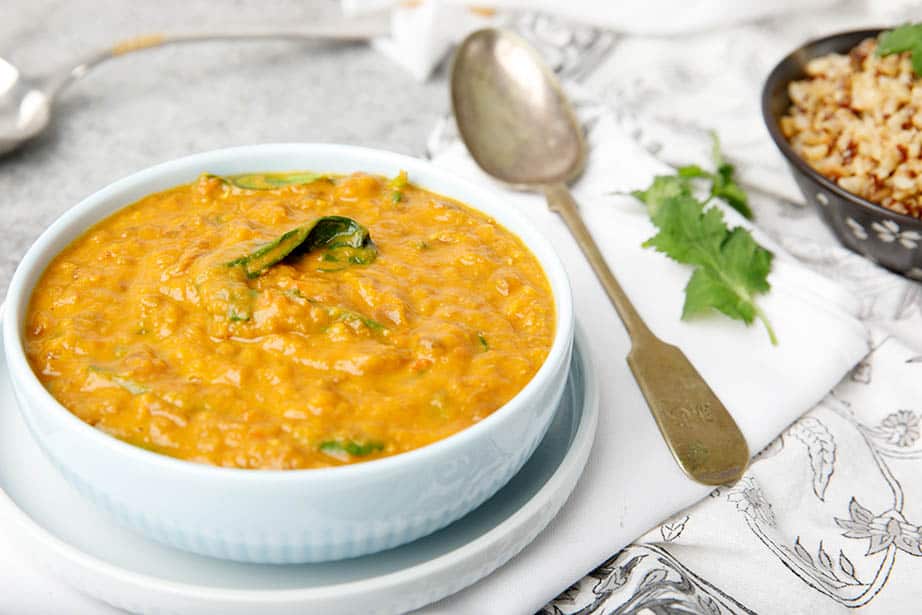 landscape image of Thermomix spicy lentil soup on table with spoon