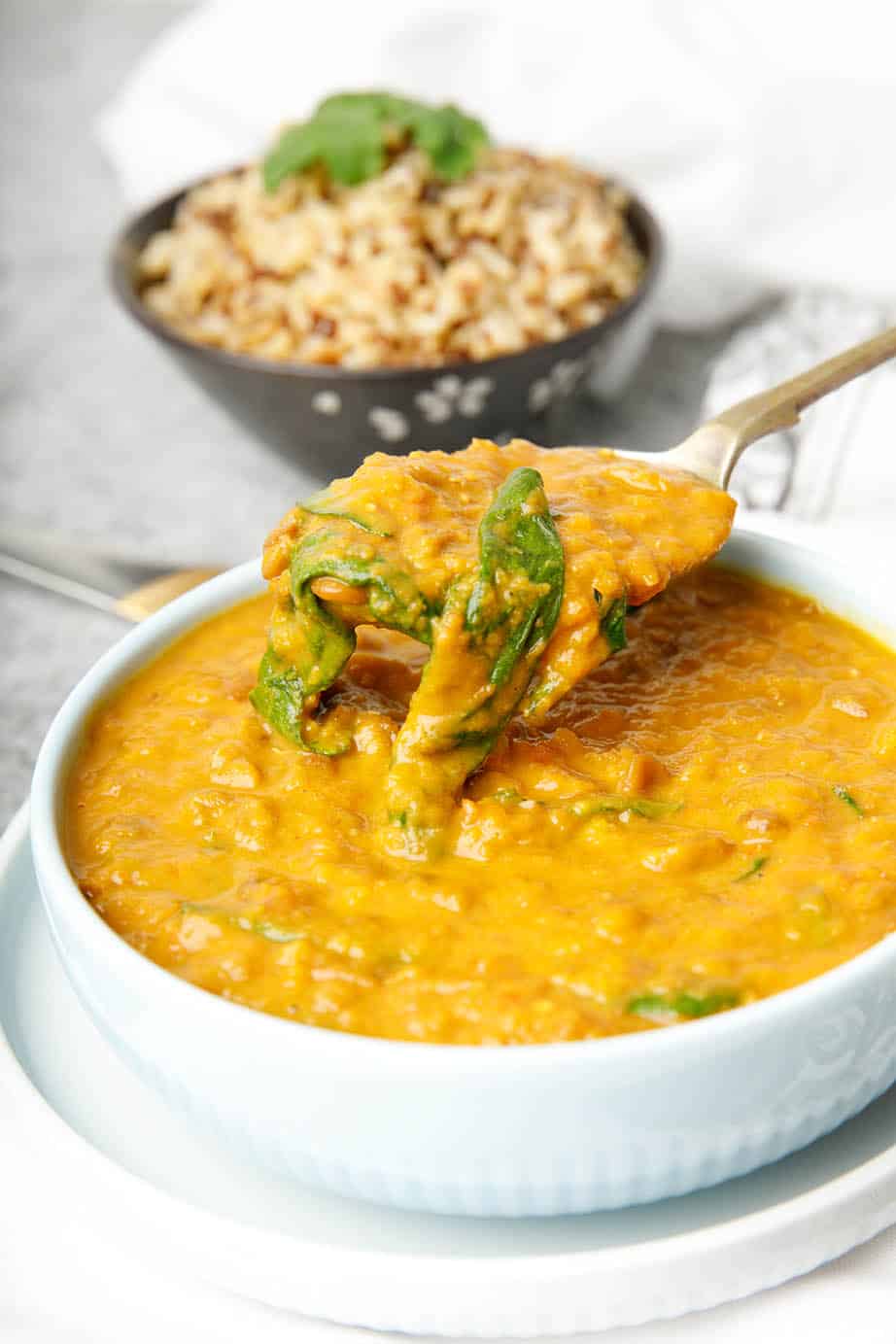 Close up Thermomix lentil soup with pumpkin and spinach on white cloth