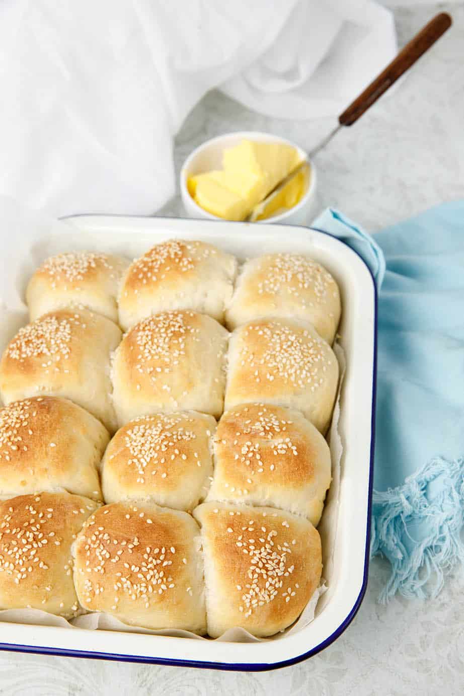 Bread recipe used to make white bread rolls. Image photographed on a ligh background with light blue napkinrolls