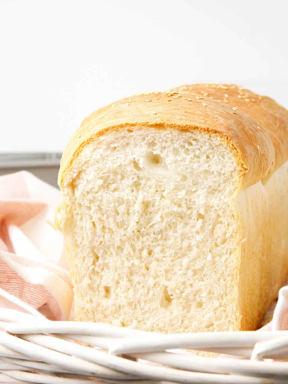 Sliced basic bread recipe loaf on a striped tea towel