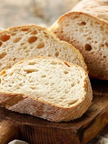 The image shows bread which has been proofed and baked on a cutting board