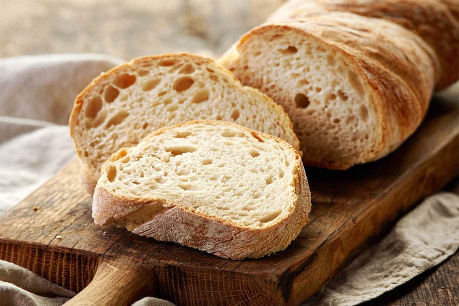 The image shows bread which has been proofed and baked on a cutting board