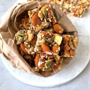 Nut bar in a brown lunch bag on a marble background