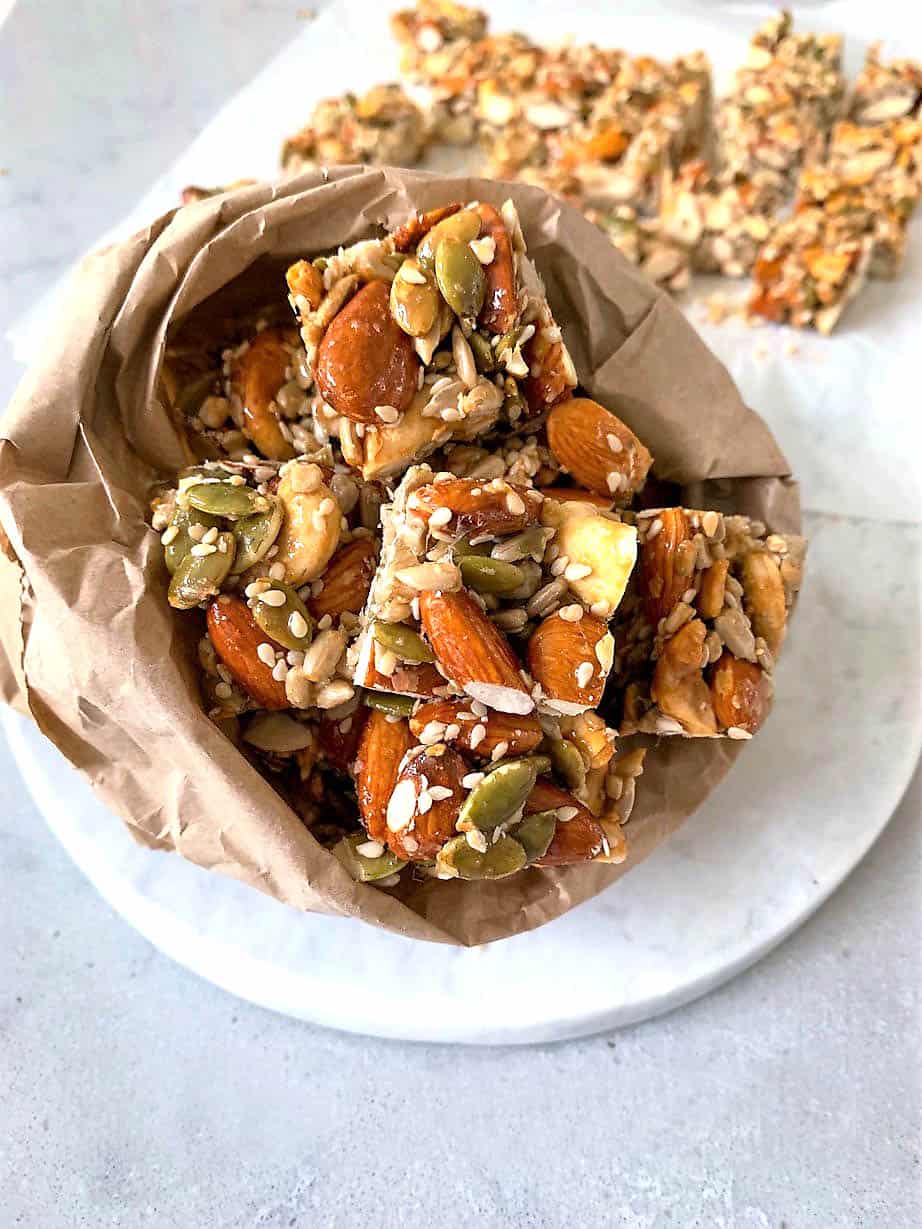 Nut bar in a brown lunch bag on a marble background