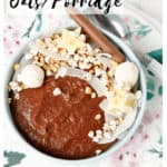 Image of chocolate oatmeal in a bowl topped with banana wheat puffs and coconut, with a title for pinterest