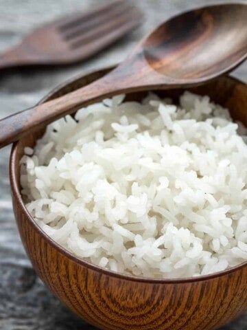 White sticky rice in a wooden bowl grey background