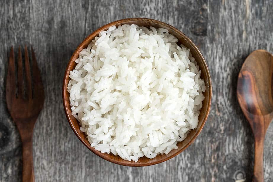 Overhead shot White sticky rice in a wooden bowl grey background