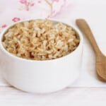 Cooked Brown Rice in a white bowl pink background