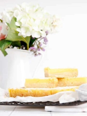 Landscape image of lemon slice cut into bars on a cooling rack.