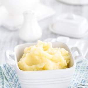 Portrail image fluffy mashed potato on a blue tea towel, white background