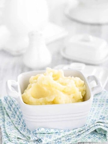 Portrail image fluffy mashed potato on a blue tea towel, white background