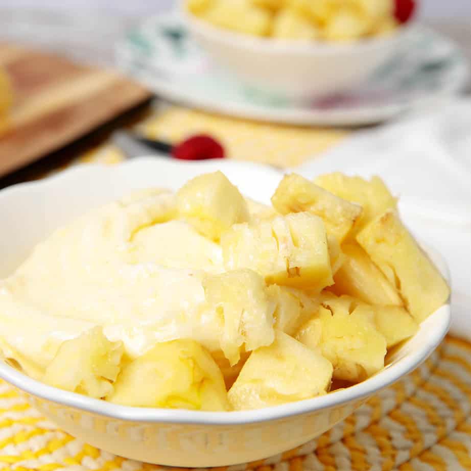 A bowl of pineapple dole whip with added cubed pineapple