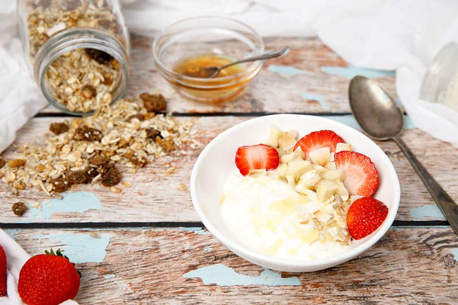 Greek yoghurt served with fruit on a wooden background